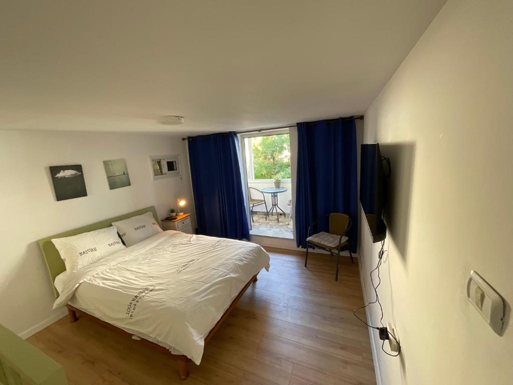 ein Schlafzimmer mit einem Bett und einem großen Fenster in der Unterkunft Green gallery in Haifa