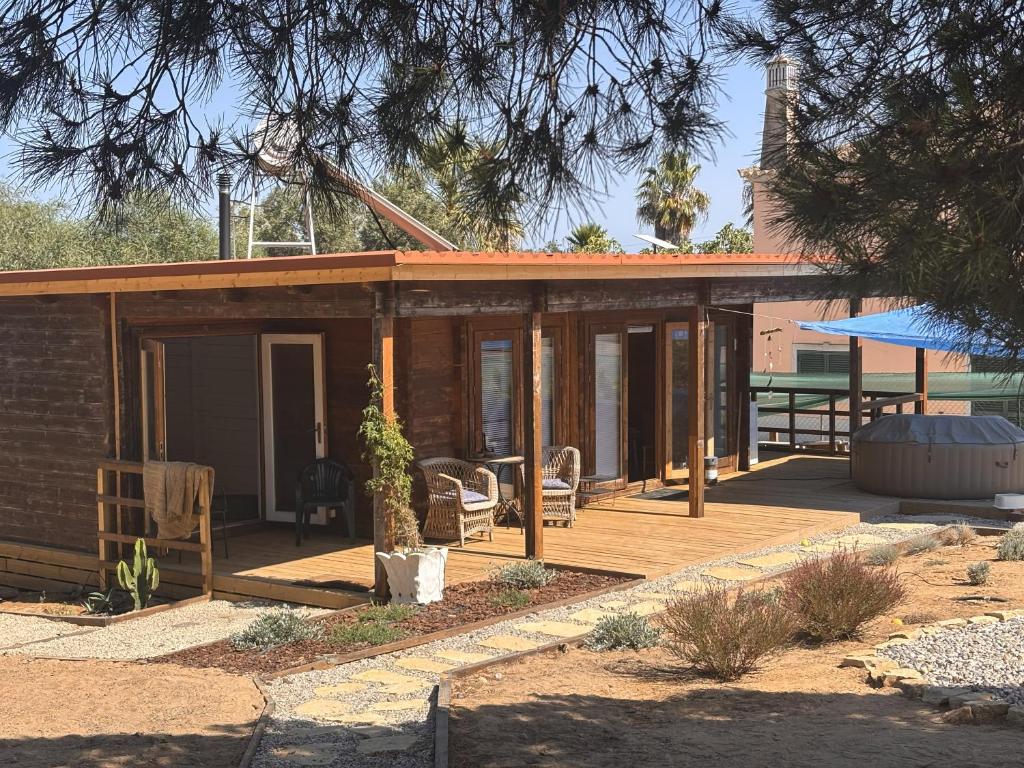 a house with a wooden deck with a patio at Casa na Colina in Almancil