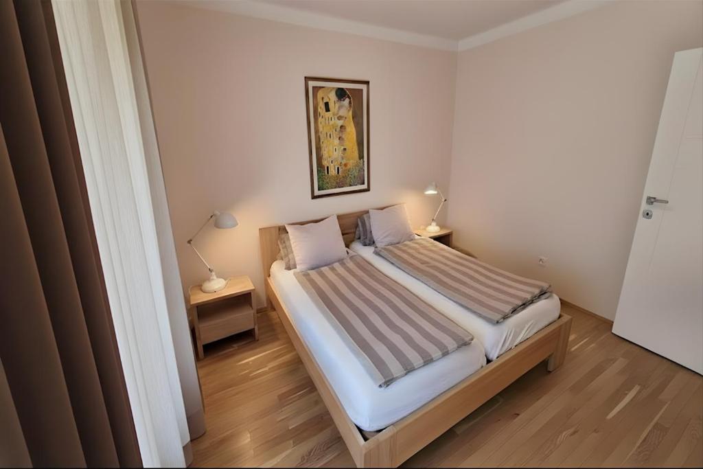 a bedroom with a bed and two night stands and two lamps at Apartment Katamaran in Krakow