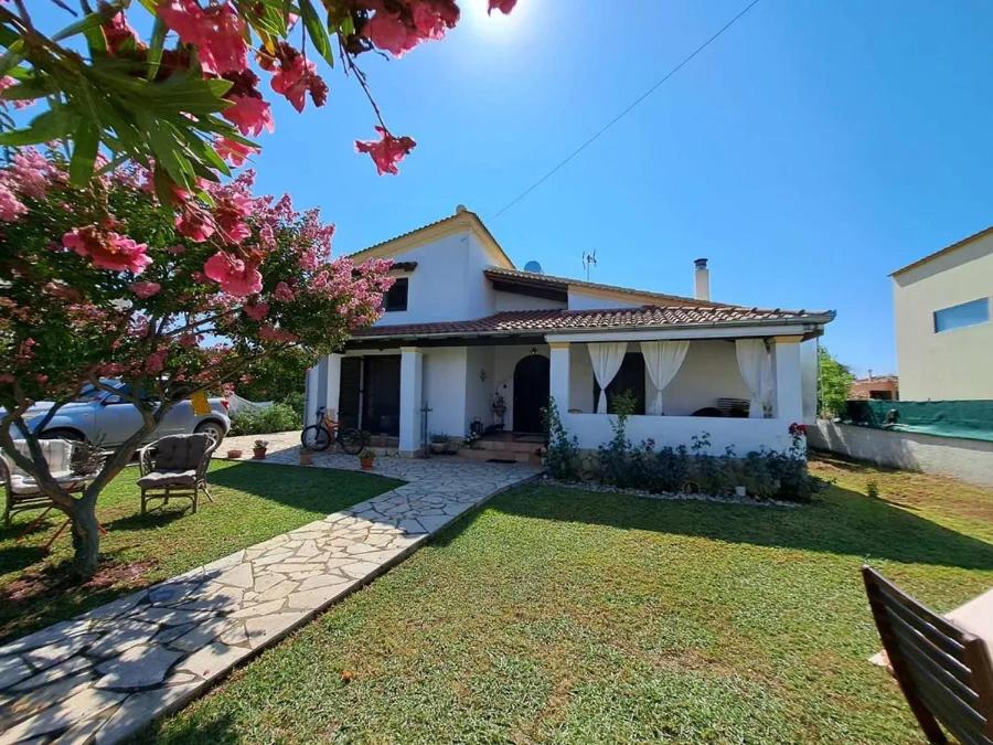 a small white house with a yard with a yard at Ektor Villa in Agios Georgios