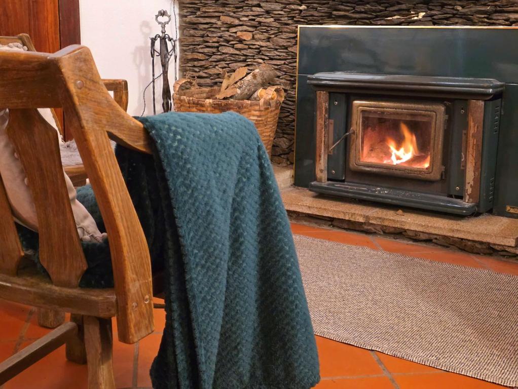 a person sitting in a chair in front of a fireplace at Casa do Rio, Natureza - Nova Gestão in Melgaço