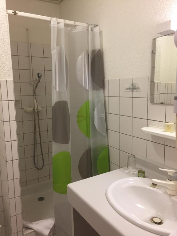 a bathroom with a shower and a sink at Hôtel Panorama in Munster