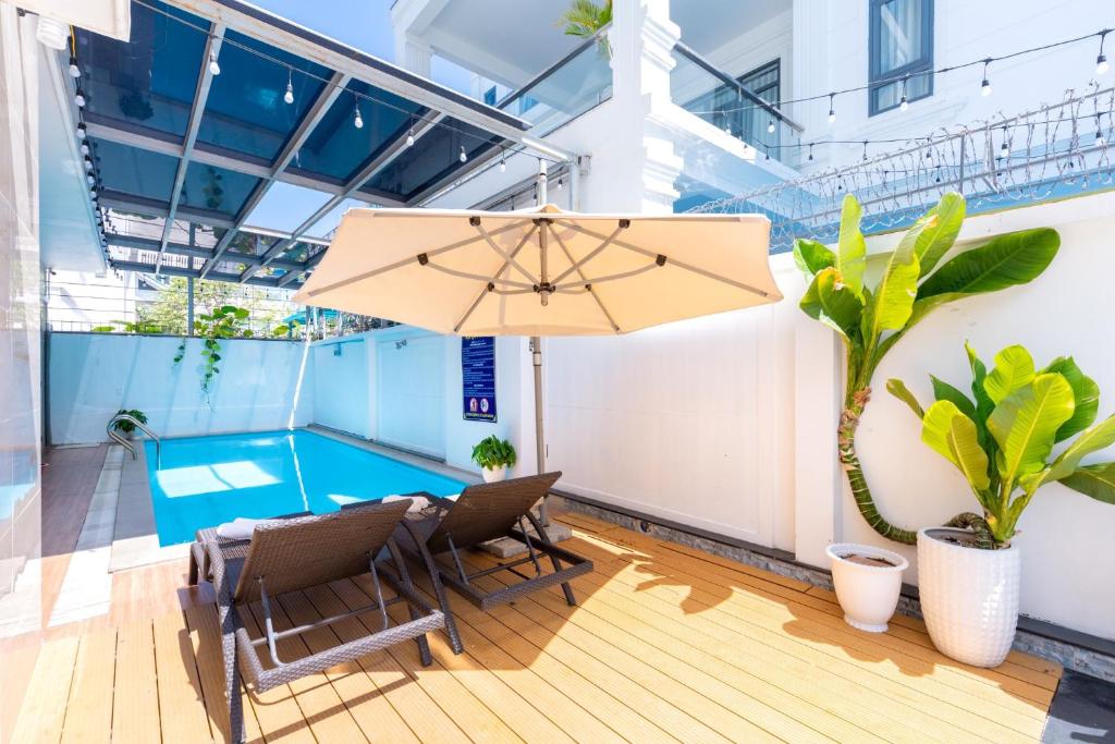 a patio with a table and chairs and an umbrella at B2-11 Hoàng My Villa in Vung Tau