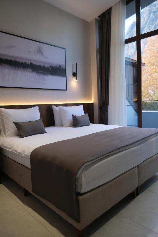 a large bed in a bedroom with a large window at 1921 justa sefa otel in Amasya