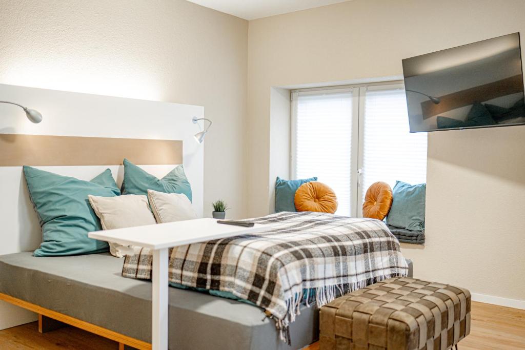 a bedroom with a bed with a table and a tv at Pension Elisa in Bad Friedrichshall