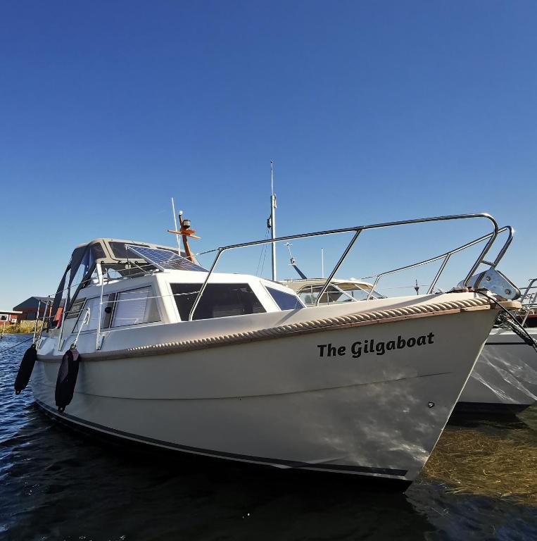 a white boat is docked in the water at Sleeping on the GilgaBoat! in Nakskov
