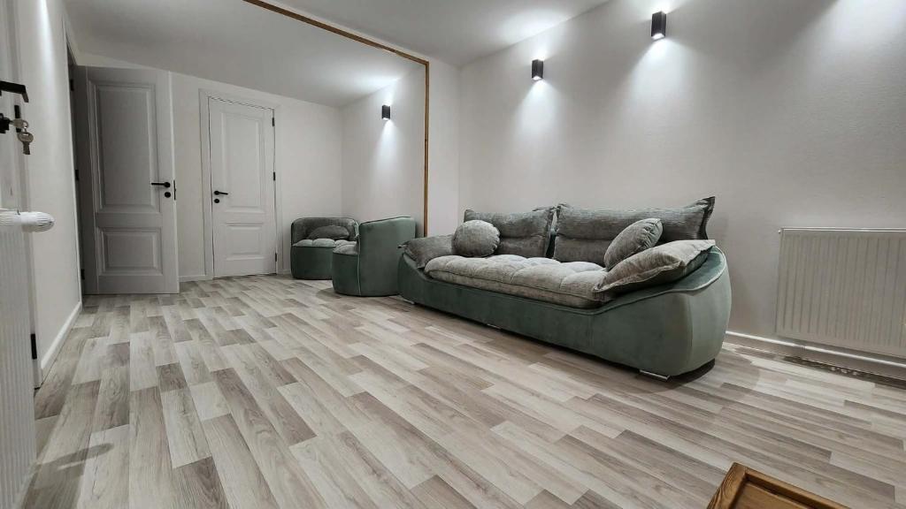 a living room with a couch and a wooden floor at Harmony house in Bakuriani