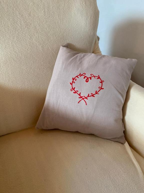 a pillow with a heart on it sitting on a couch at Maisonnette ardéchoise au centre du village in Nozières