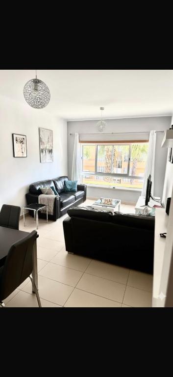 a living room with a couch and a window at Cabanas Penthouse Apartment in Cabanas de Tavira