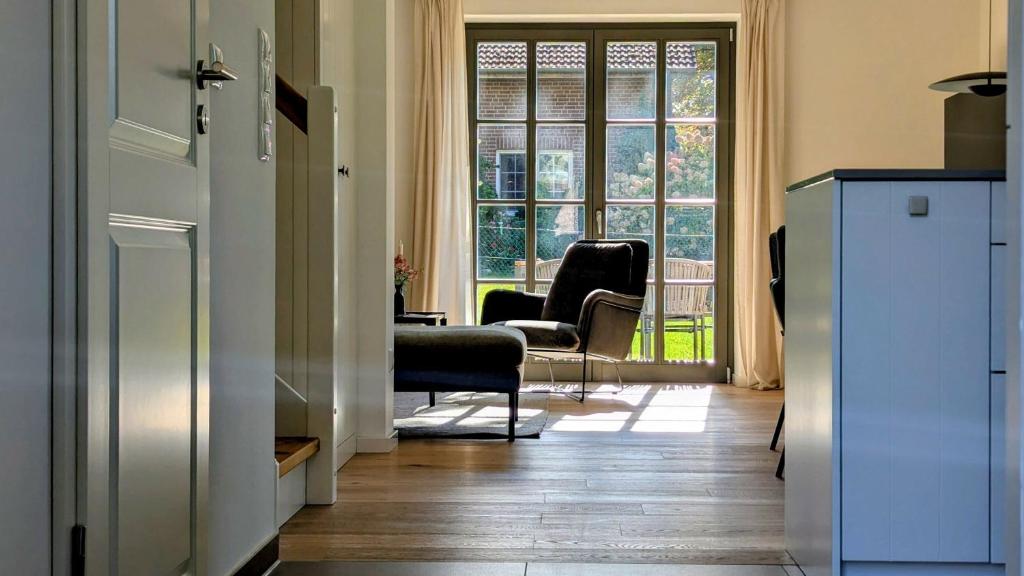 eine Küche mit einem Wohnzimmer mit Stühlen und einem Fenster in der Unterkunft Ferienhaus Calluna Stilvolle Doppelhaushälfte in der Lüneburger Heide, Hunde willkommen in Winsen
