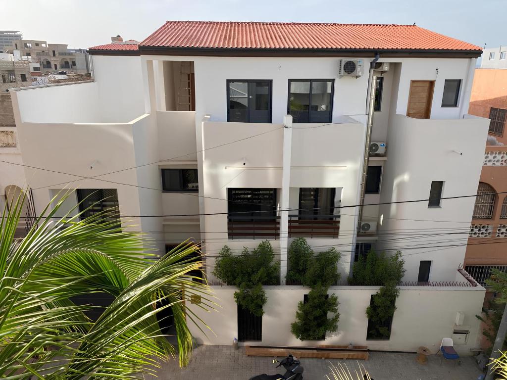 a white house with plants in front of it at ZenKai Mamelles Hotel in Dakar