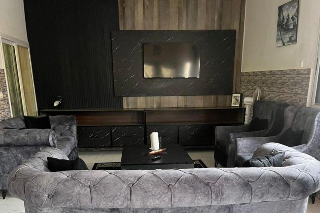 a living room with two couches and a flat screen tv at Sendou Cabano Villa Sleeps 6 with Parking in Siendou