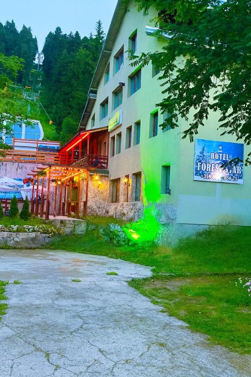 a building with a sign on the side of it at Hotel Forest Star on the Ski Slope in Borovets