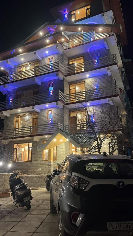 a building with cars parked in front of it at night at Liora Stays in Palchān