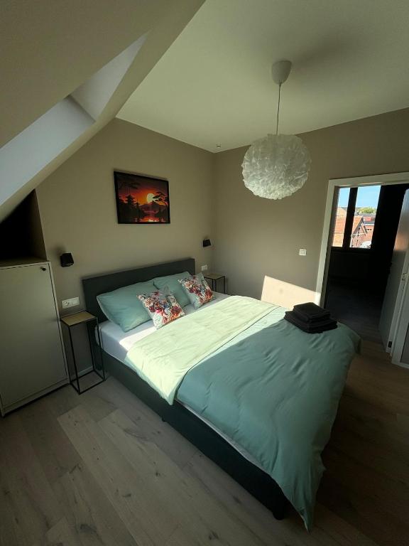 a bedroom with a bed and a chandelier at Minimalist apartment - Lier center in Lier