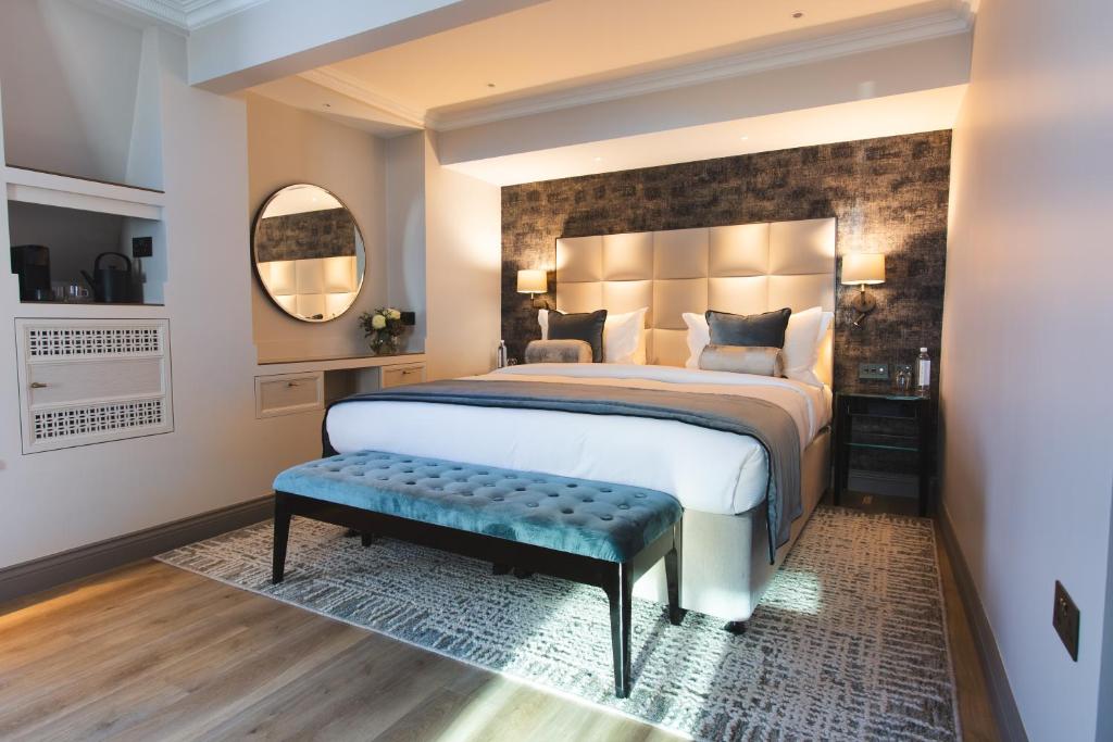 a bedroom with a large bed and a large mirror at The Rathbone Hotel, Fitzrovia in London