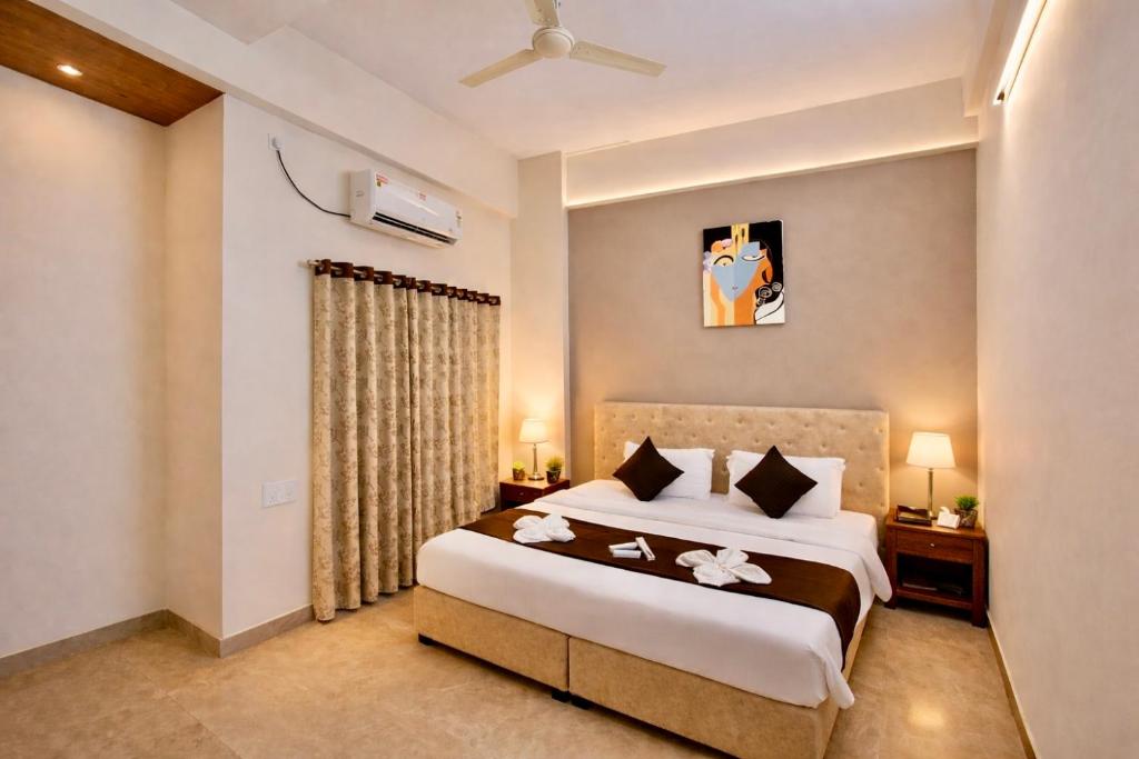a bedroom with a large bed and a window at Hotel Sai 9 Heaven A Quality Apartment Perfect for Families in Shirdi