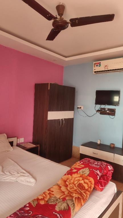 a bedroom with a bed and a tv on the wall at Hotel Mainak Mandarmoni in Mandarmoni