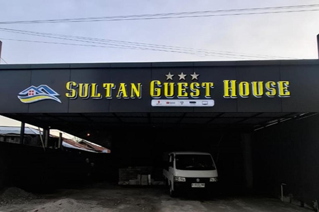 a sudan guest house with a white van parked under it at Sultan Guest House in Palu