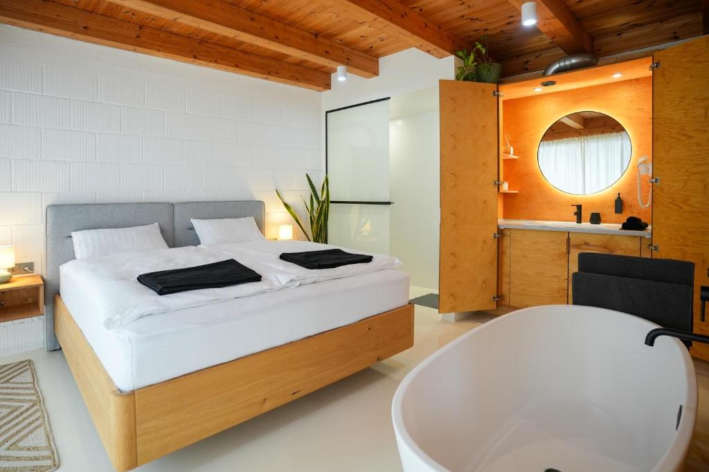a bedroom with a large bed and a bath tub at GG3 guesthouse in Eger