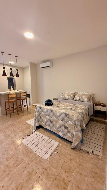 a bedroom with a large bed and a table at Studio de Hóspedes - 150m da Praia in Rio de Janeiro