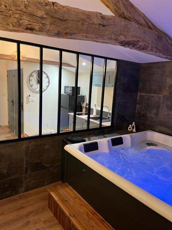 a large blue tub in a room with a clock at La Merletière in Cholet
