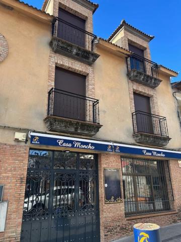 a store front of a building with a fence at Hotel Cadalso - Casa Moncho in Cadalso de los Vidrios
