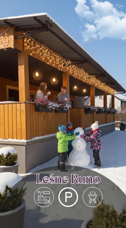 two children playing with a snowman in front of a house at Leśne Runo - Bałtów Centrum in Bałtów