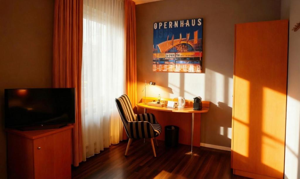 a room with a desk and a table and a television at Hotel Ambiente in Dortmund