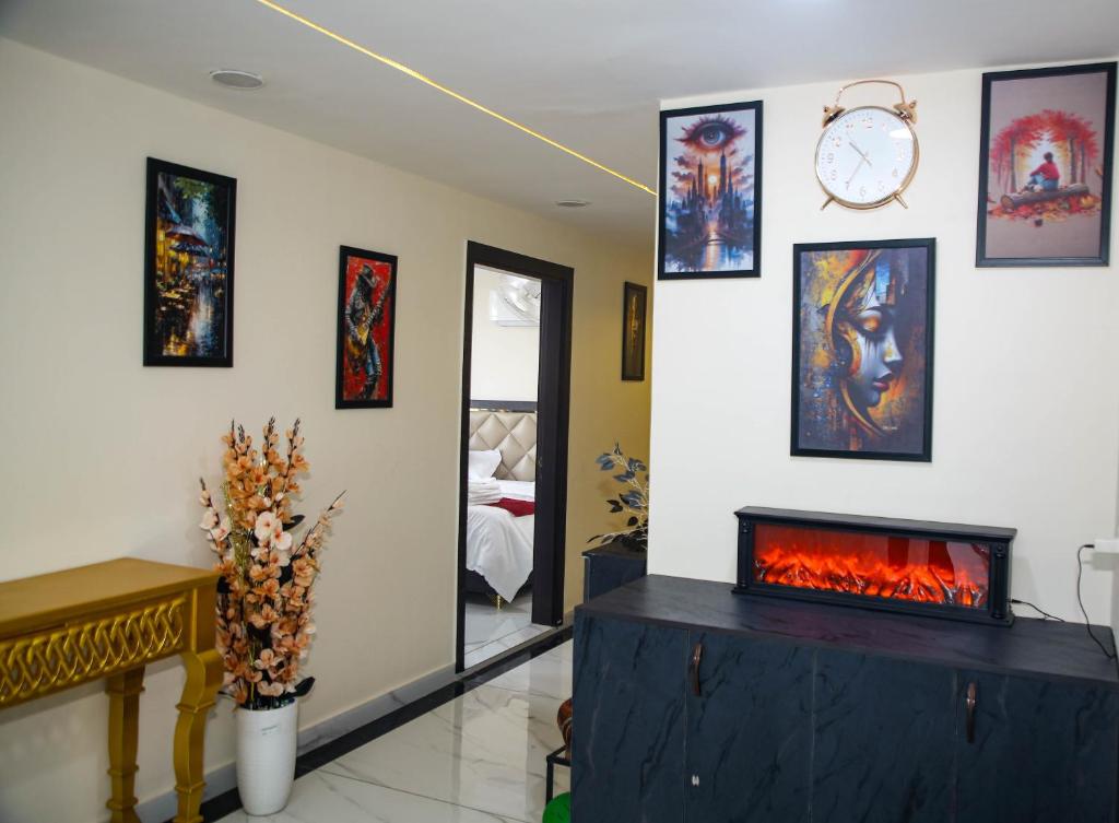 a room with a fireplace and paintings on the wall at The Manor Inn in Phagwāra