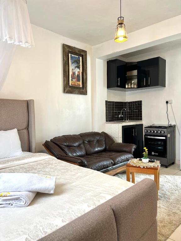 a living room with a bed and a couch at Rustic studio milimani in Kisumu
