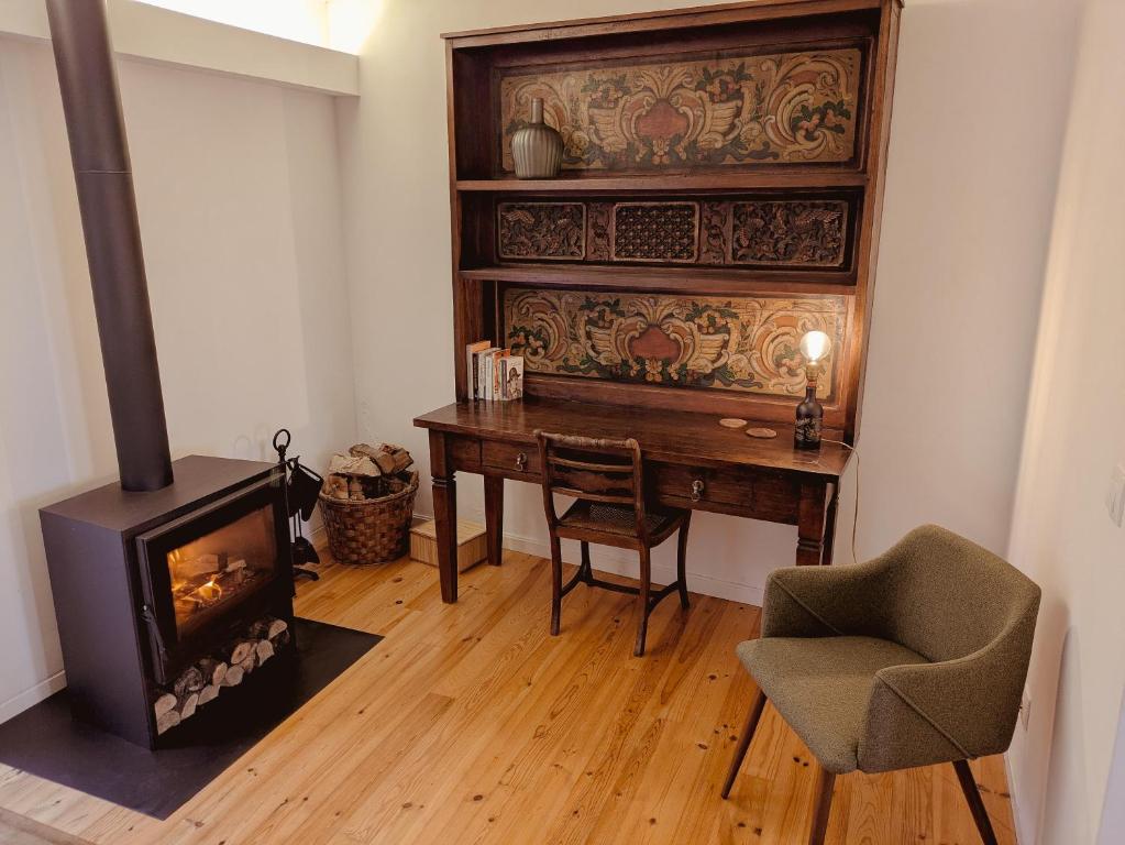 a room with a desk and a wood stove at Casa da Delonga in Nordeste
