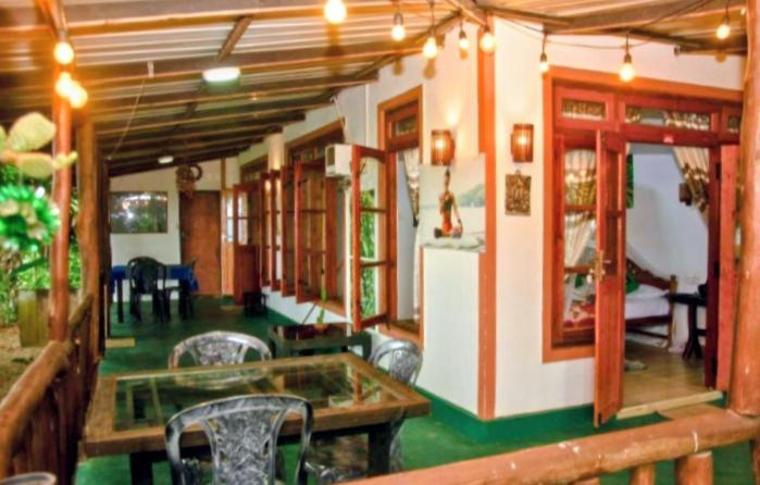 a room with chairs and a table and a refrigerator at Bliss In Viya in Ella