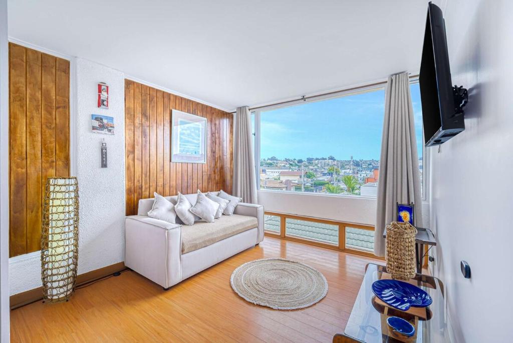 a living room with a white couch and a large window at Costa Azul- 3D Seafront Apartment in Algarrobo