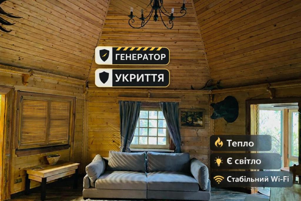 a living room with a couch and signs on the ceiling at Ethno Complex Ukrayinske Selo in Buzovaya