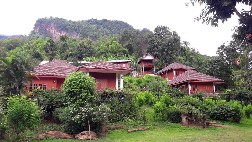 a row of red houses on a hill with trees at Saen Kam Resort in Ban Tham