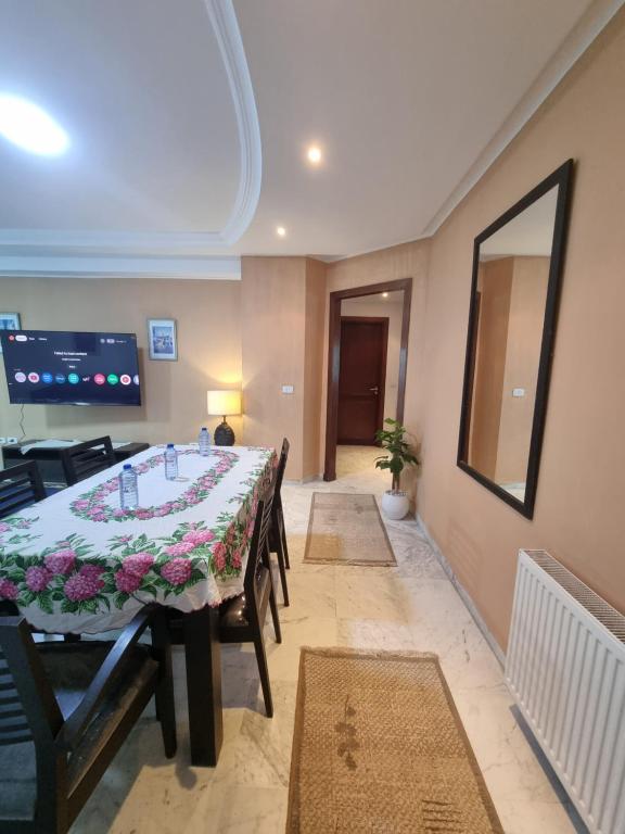 a dining room with a table and chairs and a television at Luxury home tunisia mall lac 2 in Tunis