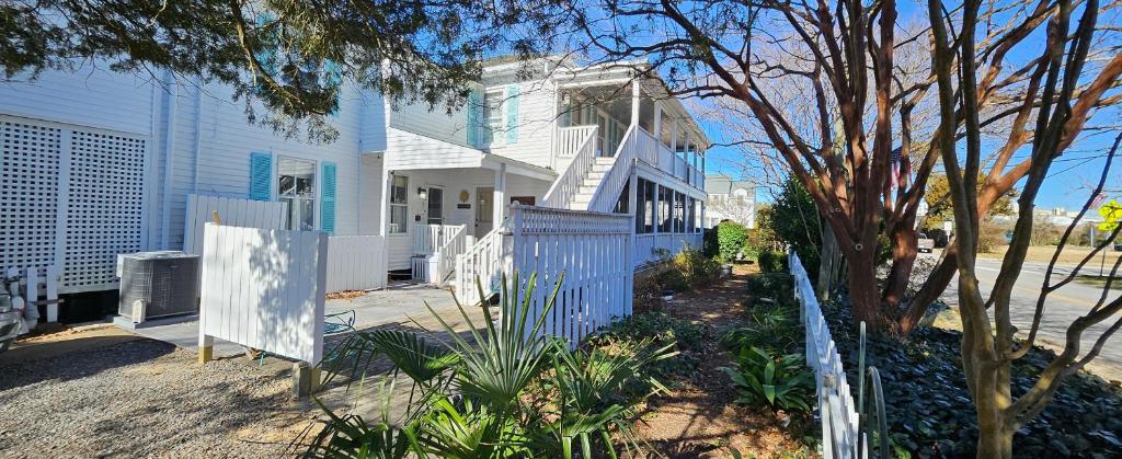a white house with a blue fence in front of it at Barclay Cottage Inn in Virginia Beach