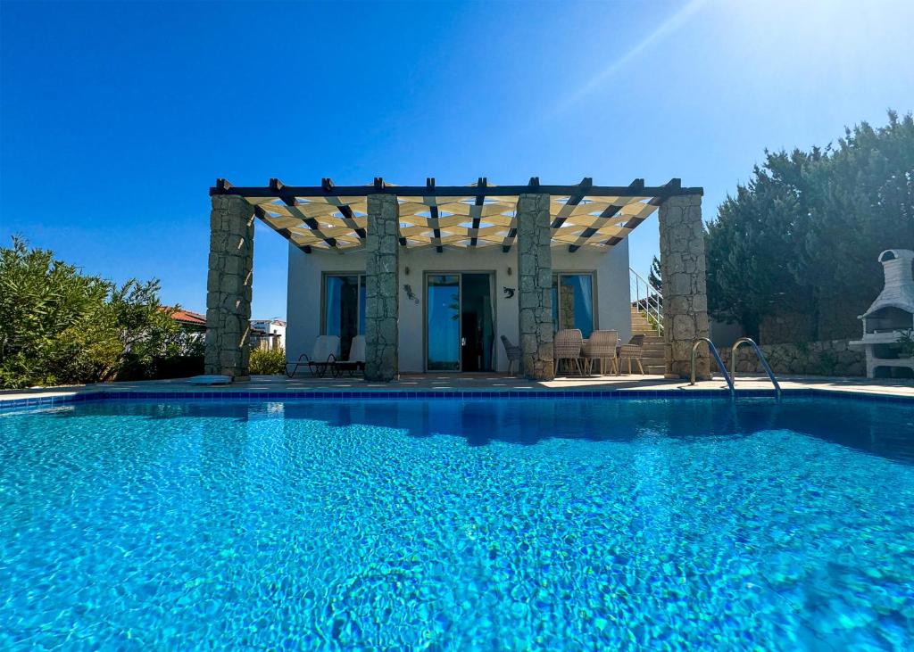 a swimming pool in front of a house with a pergola at Villa Sea View in Kyrenia