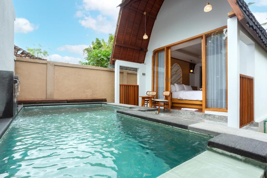 a swimming pool in a villa with a bedroom at Merta Luwih Villa in Tanah Lot