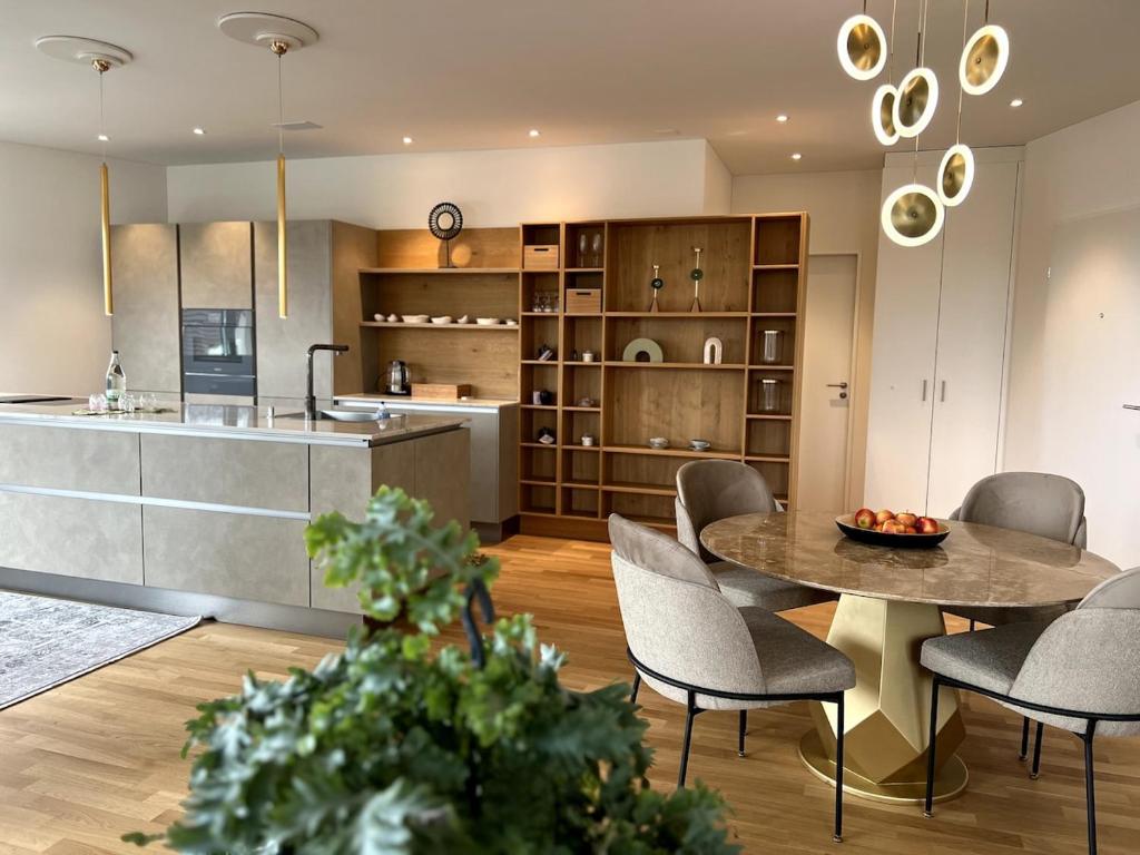 a kitchen and dining room with a table and chairs at New and elegant luxury apartment in Kloten