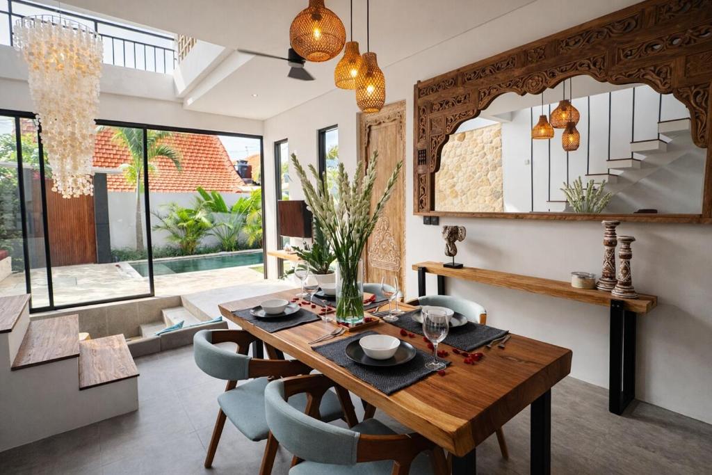 a dining room with a wooden table and chairs at 2BR Villa Surrounded by Rice Fields Cemagi in Cemagi