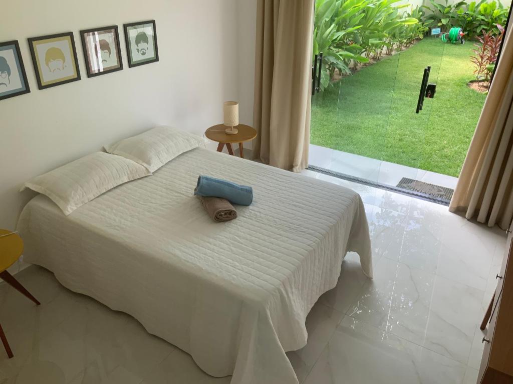 a white bed with a blue towel on top of it at Casa dos cajueiros in Paracuru