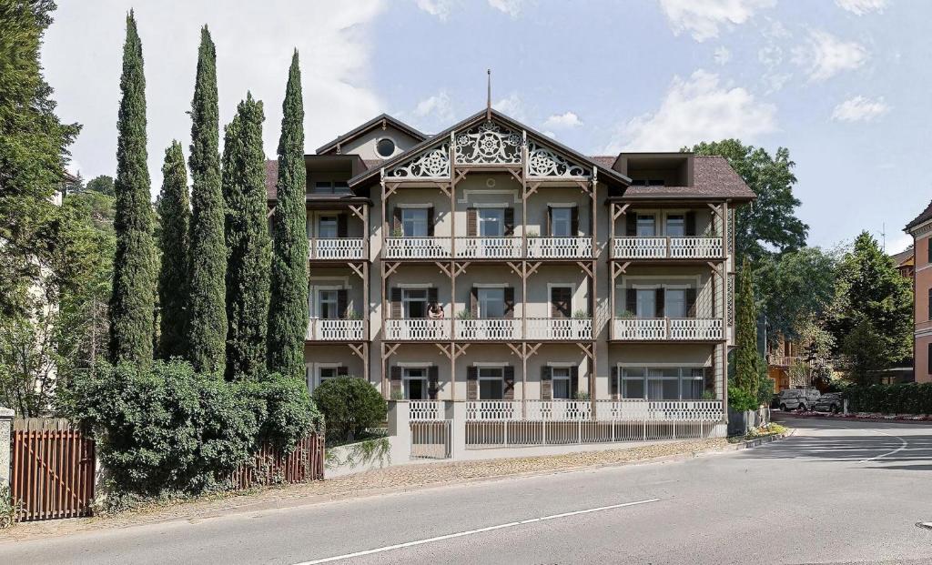 an apartment building with a balcony on a street at Villa Rosengarten Guesthouse in Merano