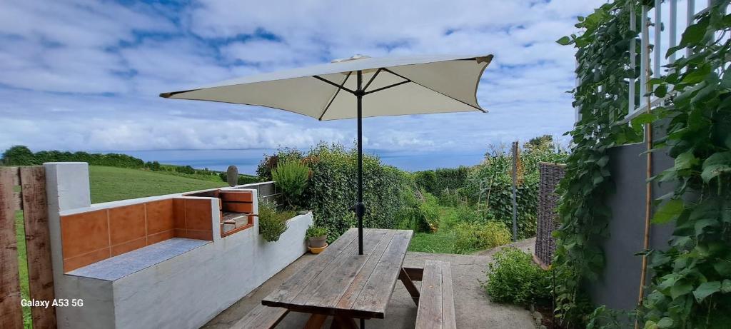 a picnic table with an umbrella on a patio at Lar da Rita - One bedroom apartment in Água Retorta