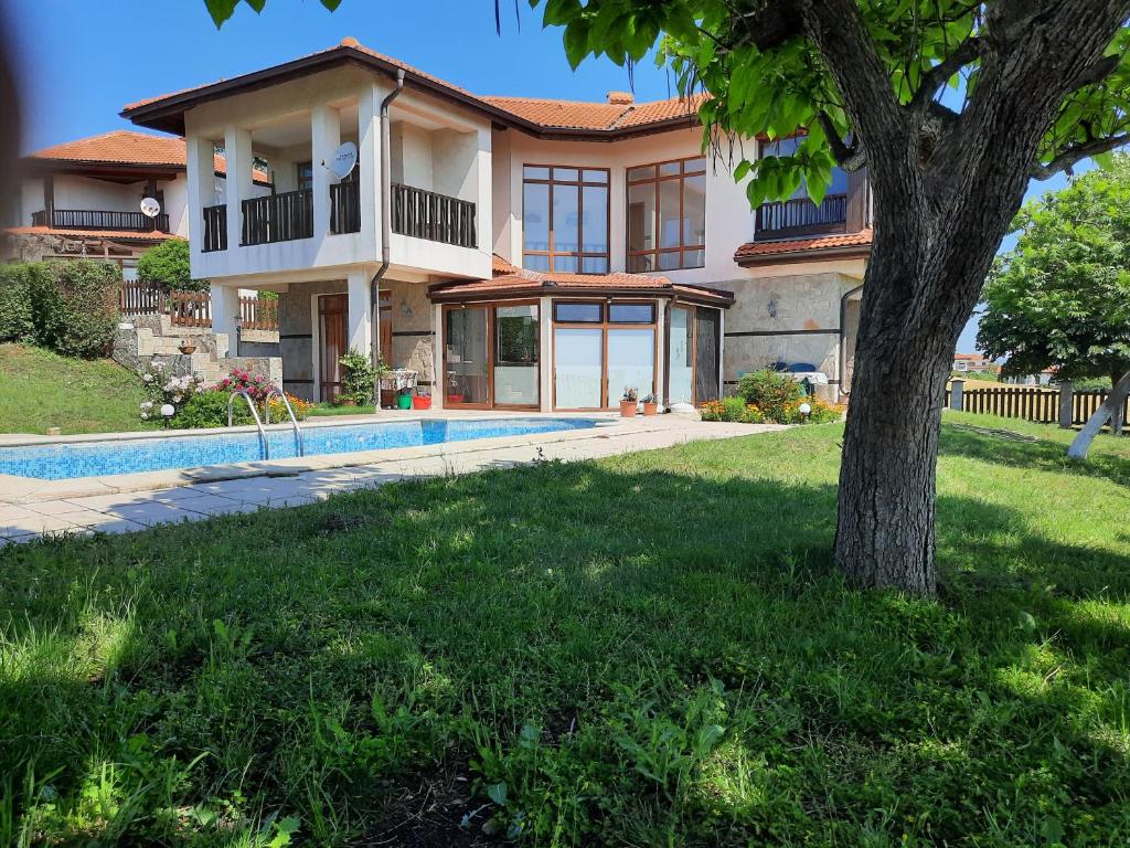 a house with a swimming pool and a tree at Villa Jasmin in Aheloy