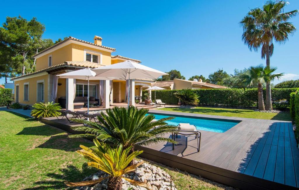 a villa with a swimming pool and a house at Montelago in Alcudia