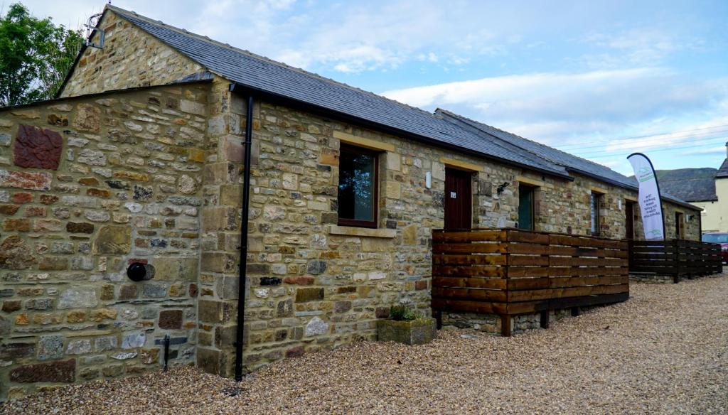 an old stone building with a large wooden at 3 Peaks Bunkroom in Settle