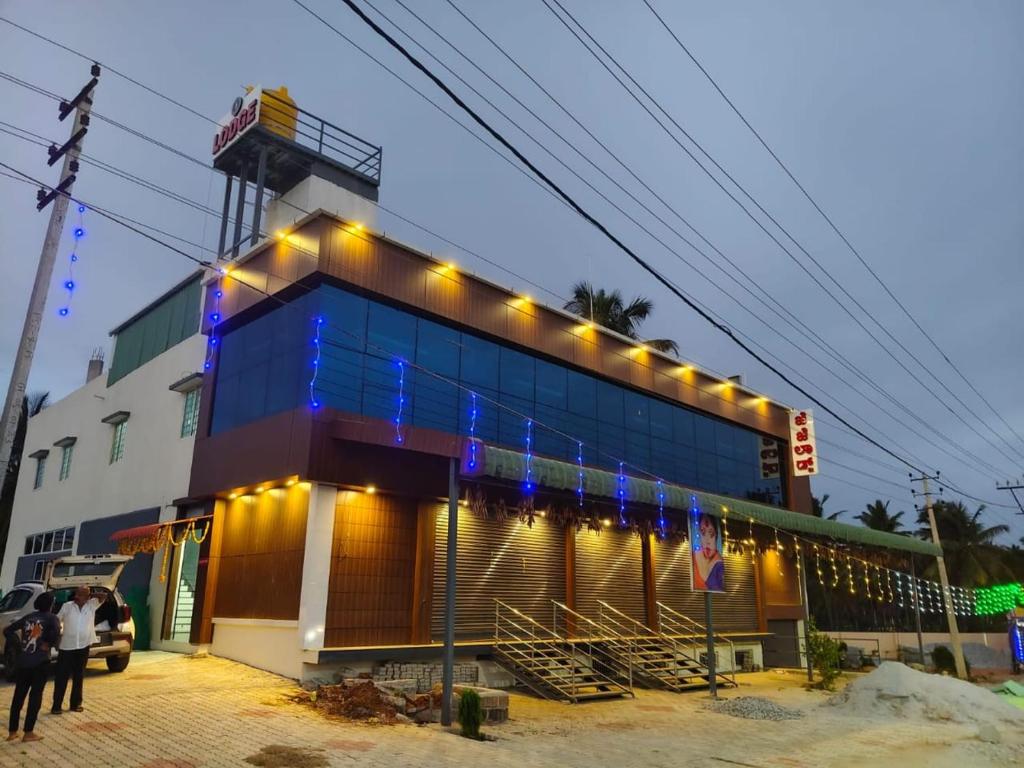 a building with lights on the side of it at JJ Comfort Hotel in Turuvekere