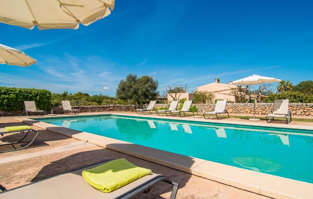 a swimming pool with chairs and umbrellas at Son Capellot Uno in Felanitx